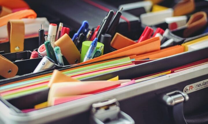 assorted pen and colored papers in organizer case